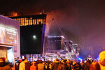 Пожарные тушат горящую крышу концертного зала «Крокус Сити Холл», где произошла стрельба, 22 марта 2024 года