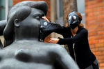 Группа экологов надевает противогазы на скульптуры художника Фернандо Ботеро, протестуя против высокого уровня загрязнения воздуха в Медельине, Колумбия