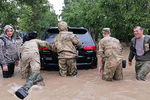 Военнослужащие помогают местному жителю толкать автомобиль на затопленной улице в Керчи, 17 июня 2021 год