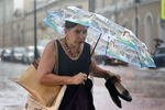 Женщина на одной из улиц города во время дождя, 28 июня 2021 года