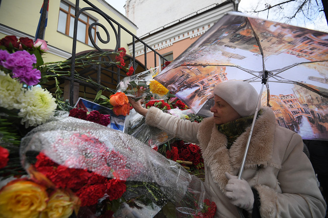 Женщина возлагает цветы к посольству Кубы в Москве