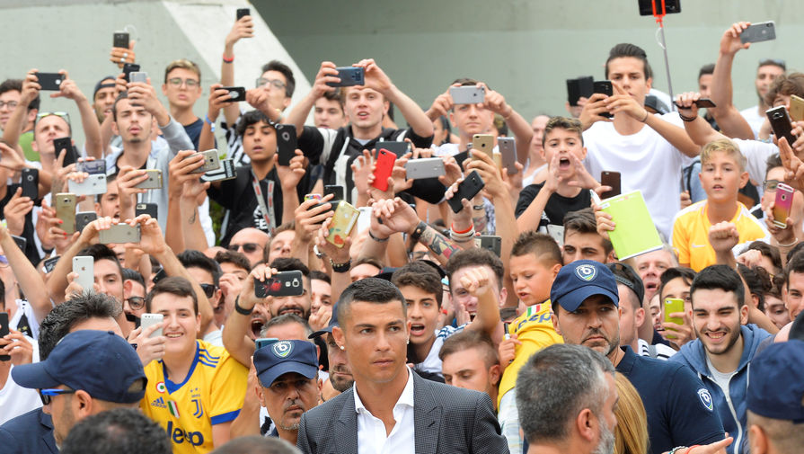 Криштиану Роналду в аэропорту Турина в окружении болельщиков «Ювентуса»