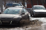 Автомобили на одной из улиц города. Резкое потепление привело к повышению уровня талых вод до 40 см