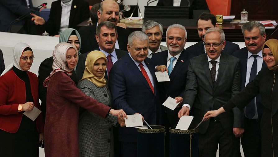 Премьер-министр Турции Бинали Йылдырым (в центре) и депутаты турецкого парламента отдают свои голоса в поддержку проекта конституционной реформы, которая предполагает переход на президентскую модель правления