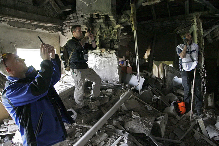 Сотрудники миссии ОБСЕ, прибывшие на&nbsp;место обстрела жилого сектора Донецка, фиксируют разрушения и собирают осколки