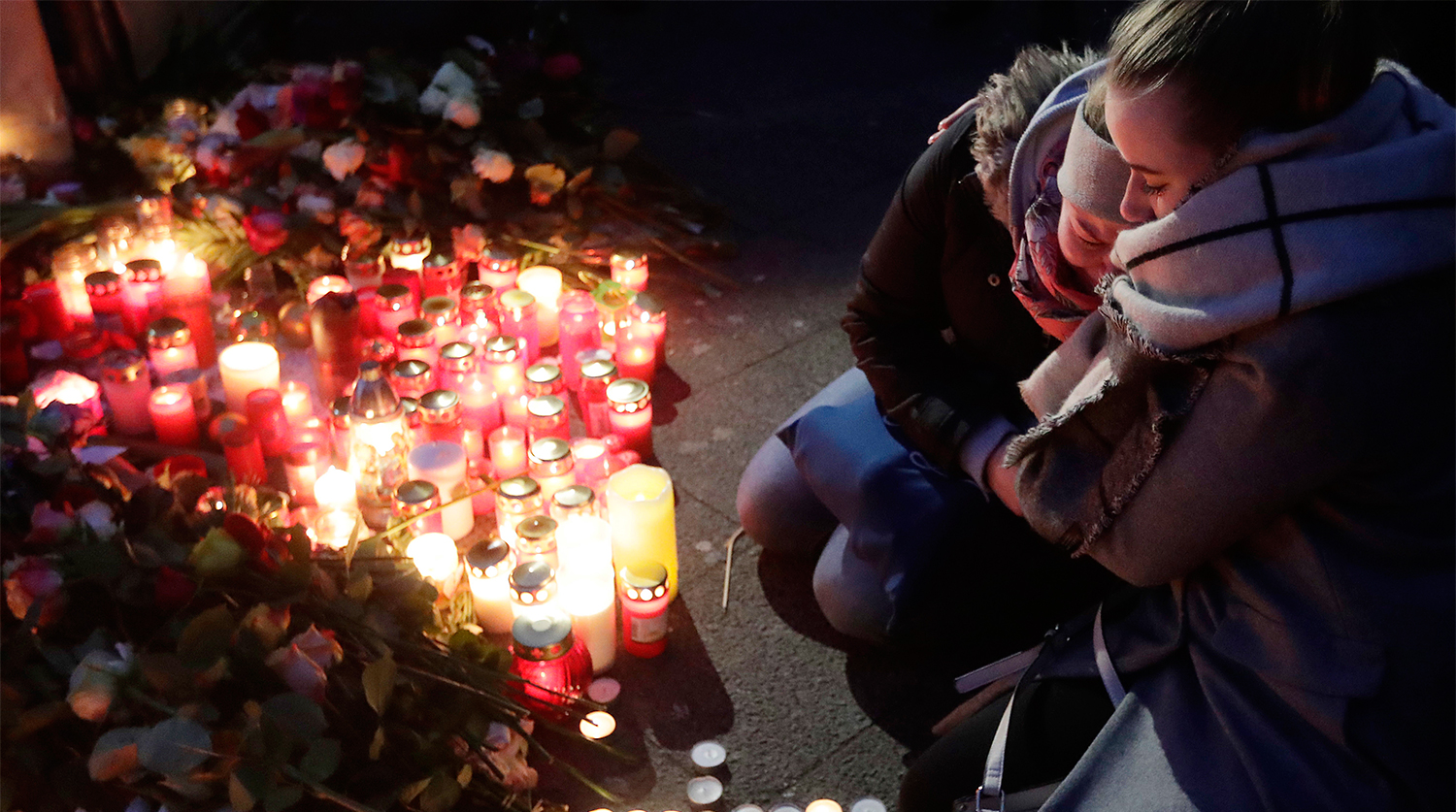 Свечи и цветы около рождественской ярмарки на площади Брайтшайдплац в Берлине, 20 декабря 2016 года