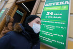 Житель Санкт-Петербурга в защитной маске у входа в аптеку