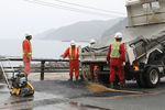 Рабочие во время ремонта дороги после землетрясения в Японии, 19 июня 2019 года 