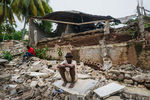 Мужчина на обломках больницы, разрушенной землетрясением, Гаити, 17 августа 2021 года