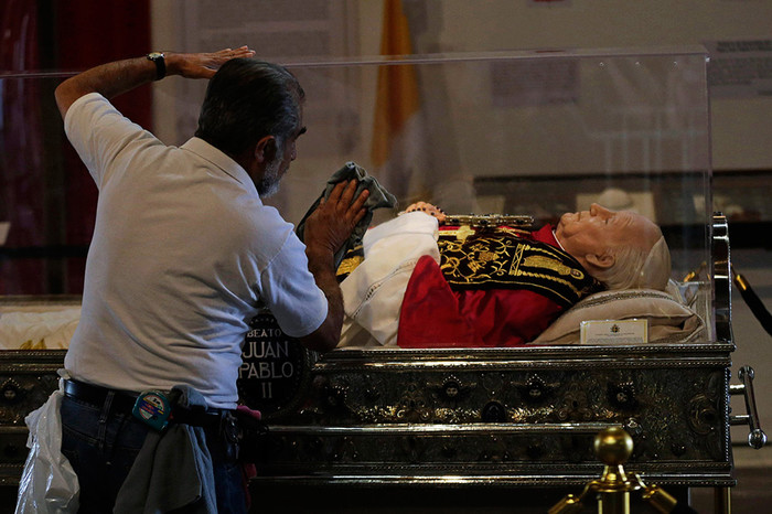 Рабочий моет стеклянный гроб с&nbsp;восковой фигурой папы Иоанна Павла II в&nbsp;базилике Марии Гваделупской в&nbsp;Мехико