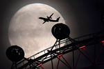 Самолет и одно из крупнейших колес обозрения в Европе — London eye на фоне суперлуния в Лондоне