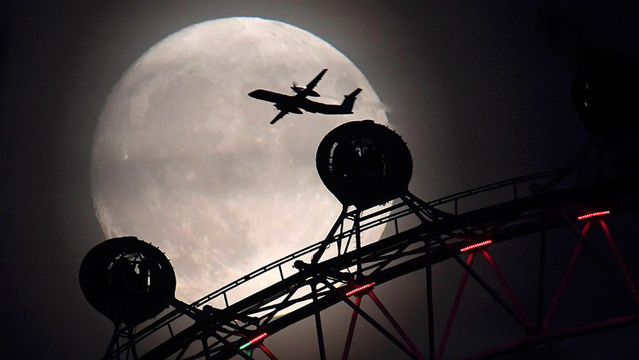 Самолет и одно из крупнейших колес обозрения в Европе — London eye на фоне суперлуния в Лондоне