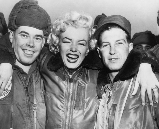К середине 1950-х Монро успела развестись с Догерти. В 1954 году она сыграла свадьбу с бейсболистом Джо Ди Маджо. Во время медового месяца в Японии звезде (которая на тот момент не только снималась в кино, но и пела) предложили выступить перед солдатами в Корее. Музыкантов в ансамбль пришлось в спешке набирать из военных. На фото Мэрилин Монро с американскими военнослужащими во время визита в Корею, 1954 год