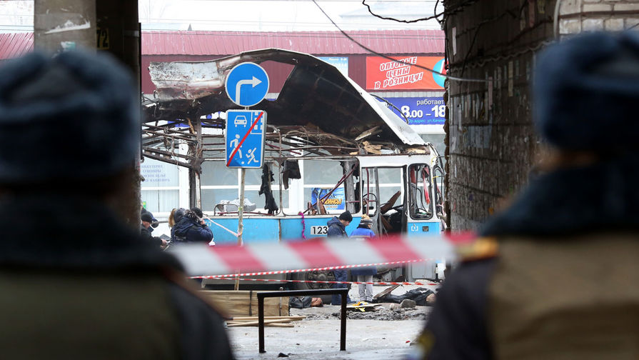 Сотрудники оперативных служб и правоохранительных органов работают на месте взрыва в троллейбусе рядом с Качинским рынком в Волгограде, 30 декабря 2013 года