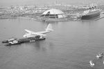 Hughes H-4 Hercules во время транспортировки в гавани Лос-Анджелеса, 1982 год. На заднем плане — трансатлантический лайнер RMS Queen Mary