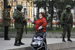 Местная жительница с детской коляской и бойцы самообороны перед украинской воинской частью А2542 в Симферополе