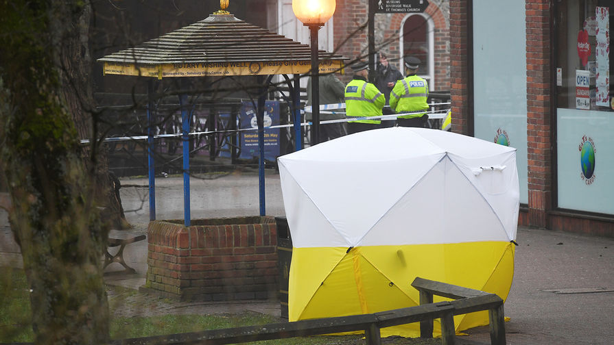 Полицейское оцепление около торгового центра в британском Солсбери после инцидента с бывшим российским разведчиком Сергеем Скрипалем, 6 марта 2018 года. Тент накрывает скамейку, где мужчина и его дочь были найдены в критическом состоянии