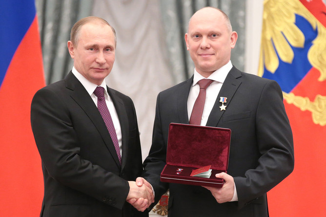 Президент России Владимир Путин и космонавт-испытатель группы космонавтов отряда космонавтов федерального государственного бюджетного учреждения «Научно-исследовательский испытательный центр подготовки космонавтов имени Ю.А. Гагарина» Олег Артемьев (слева направо), удостоенный звания Героя Российской Федерации и почетного звания «Летчик-космонавт Российской Федерации», во время церемонии вручения государственных наград в Кремле