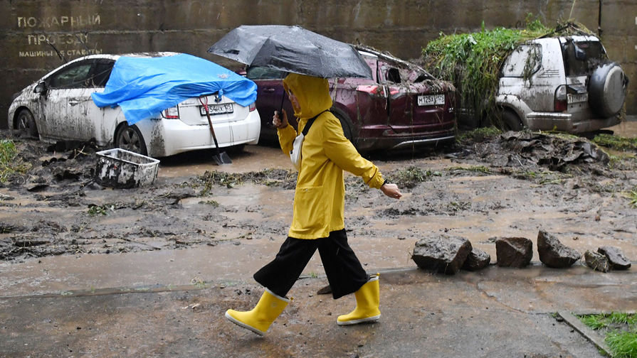 Девушка с&nbsp;зонтом на&nbsp;фоне поврежденных автомобилей в&nbsp;результате схода селя из-за сильных дождей во Владивостоке, 27 августа 2019 года