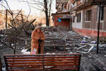 A woman near a destroyed house in Mariupol, March 2022