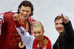 Максим Маринин и Татьяна Тотьмянина со своим тренером Олегом Васильевым (слева направо) после церемонии награждения во время зимней Олимпиады в Турине, 2006 год