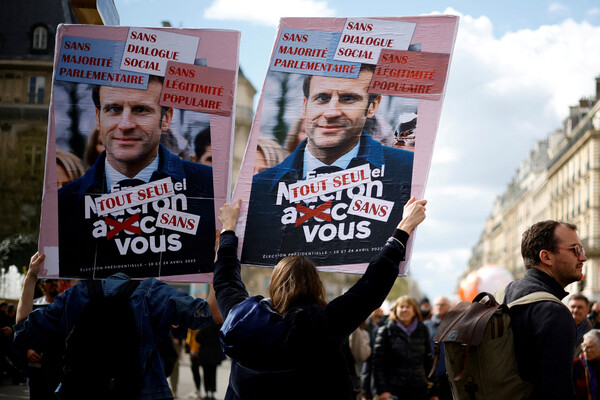 Протестующие держат плакаты с&nbsp;изображением президента Франции Эммануэля Макрона во время демонстрации против пенсионной реформы французского правительства в&nbsp;Париже, Франция, 13&nbsp;апреля 2023&nbsp;года