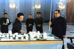 Ким Ир Сен (справа) и Ким Чен Ир (в центре) смотрят на миниатюру одной из улиц Пхеньяна