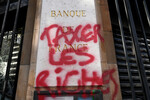 Граффити с надписью ««Обложи богатых налогами» на фасаде национального французского банка, 13 апреля 2023 года