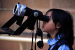 Девочка смотрит на затмение через телескоп в обсерватории Сиднея