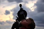 Мальчик смотрит на затмение через телескоп в обсерватории Сиднея