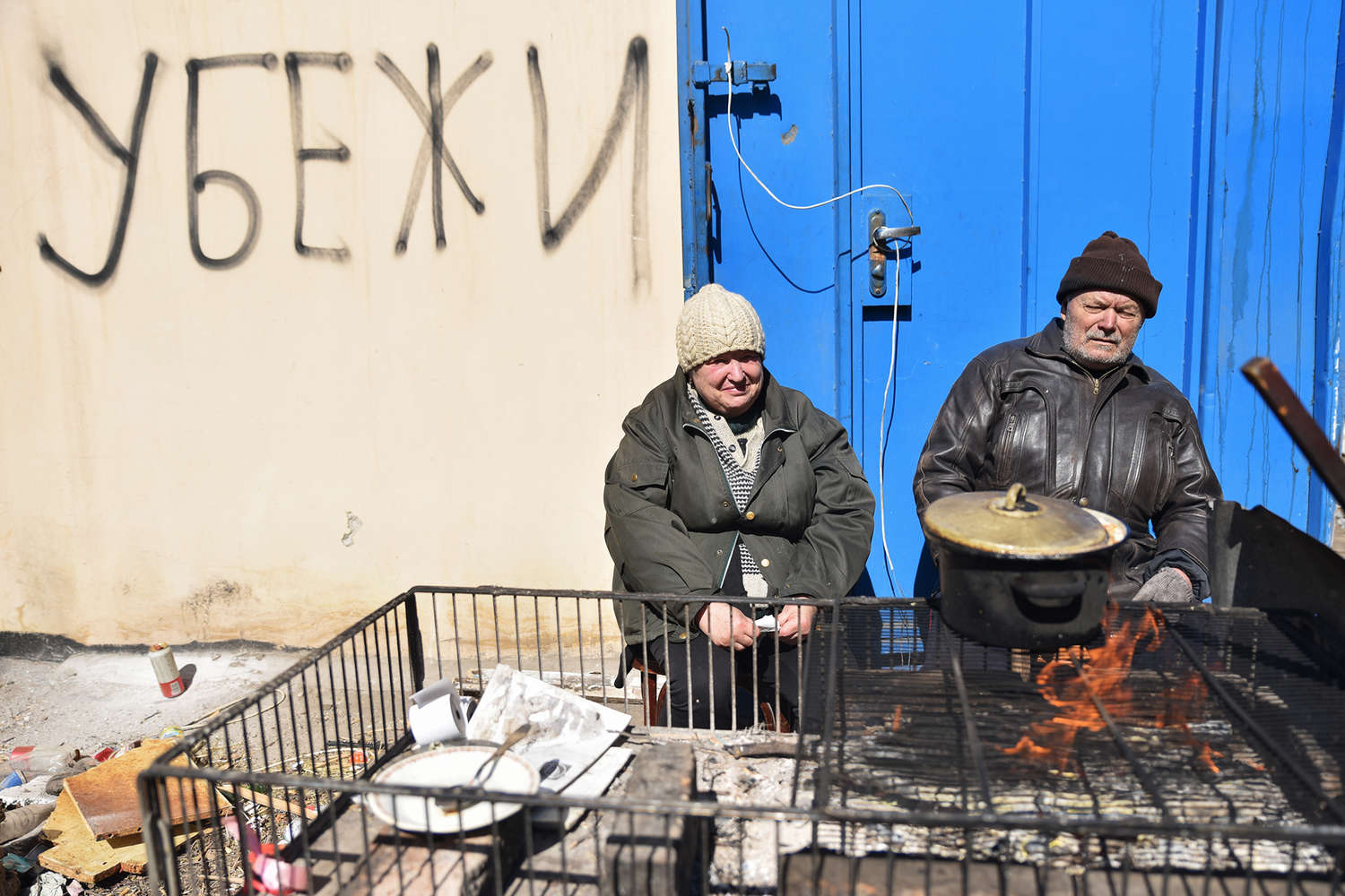 Local residents prepare food outside a bomb shelter in Mariupol, March 2022