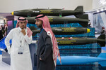 Посетители на фоне авиационных бомб на 2-й Всемирной оборонной выставке World Defense Show в Эр-Рияде
