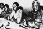 Роберт Мугабе, лидер Африканского национального союза Зимбабве (ЗАНУ) и Джошуа Нкомо, лидер Союза африканского народа Зимбабве (ЗАПУ) на пресс-конференции в Дар-эс-Салам, Танзания, 9 октября 1976 года. Когда Мугабе занял пост премьер-министра в 1980 году, он предложил Нкомо на выбор любую должность в правительстве, и он занял пост министра внутренних дел. Вскоре Мугабе обвинил Нкомо в заговоре с целью захвата власти, и тому пришлось срочно бежать из страны