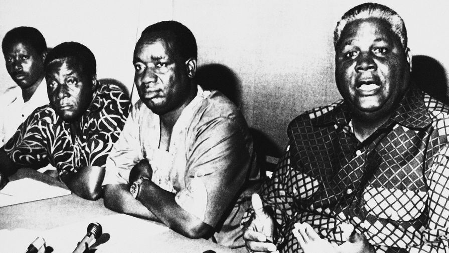 Роберт Мугабе, лидер Африканского национального союза Зимбабве (ЗАНУ) и Джошуа Нкомо, лидер Союза африканского народа Зимбабве (ЗАПУ) на&nbsp;пресс-конференции в&nbsp;Дар-эс-Салам, Танзания, 9&nbsp;октября 1976&nbsp;года. Когда Мугабе занял пост премьер-министра в&nbsp;1980 году, он предложил Нкомо на&nbsp;выбор любую должность в&nbsp;правительстве, и он занял пост министра внутренних дел. Вскоре Мугабе обвинил Нкомо в&nbsp;заговоре с&nbsp;целью захвата власти, и тому пришлось срочно бежать из&nbsp;страны