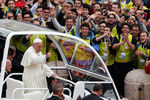 Папа Франциск приветствует верующих, проезжая в своем папамобиле после церемонии канонизации в Ватикане