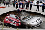 Спасатели муниципальной аварийно-спасательной службы Новосибирска готовятся к извлечению автомобилей, упавших в провалившийся грунт теплотрассы в Новосибирске, октябрь 2021 года