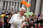 Папа римский держит воздушный шарик, подаренный ему во время общей аудиенции на площади святого Петра в Ватикане