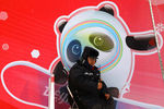 Сотрудник охраны на фоне плаката с символикой Олимпийских игр в Пекине, январь 2022 года 