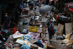 Люди идут по дороге, затопленной после проливного дождя, на рынке в Сеуле, Южная Корея, 9 августа 2022 года