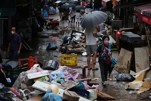 Люди идут по&nbsp;дороге, затопленной после проливного дождя, на&nbsp;рынке в&nbsp;Сеуле, Южная Корея, 9&nbsp;августа 2022&nbsp;года