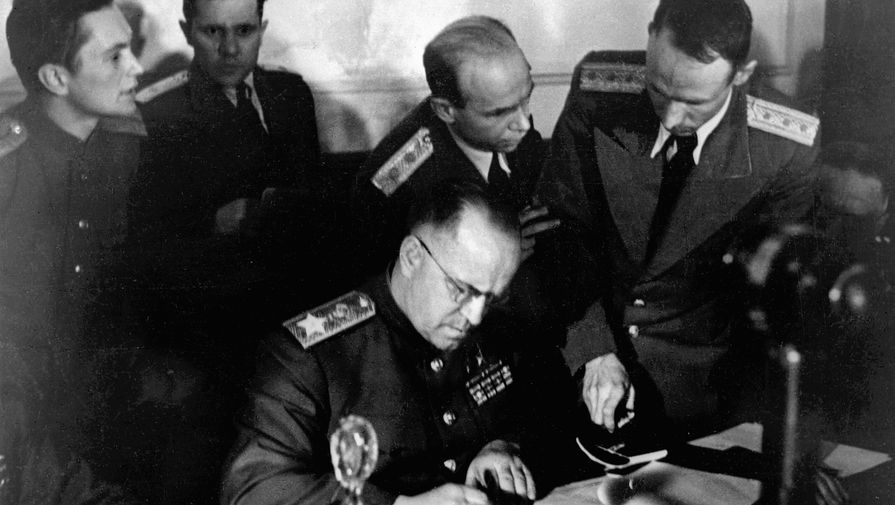 Заместитель Верховного Главнокомандующего Маршал Советского Союза Георгий Константинович Жуков (в центре) подписывает Акт о безоговорочной капитуляции фашистской Германии в Карлсхорсте, 8 мая 1945 года.