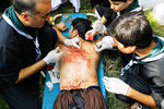 Медики зашивают порезы на спине у одного из участников шествия в День Ашура в Пакистане