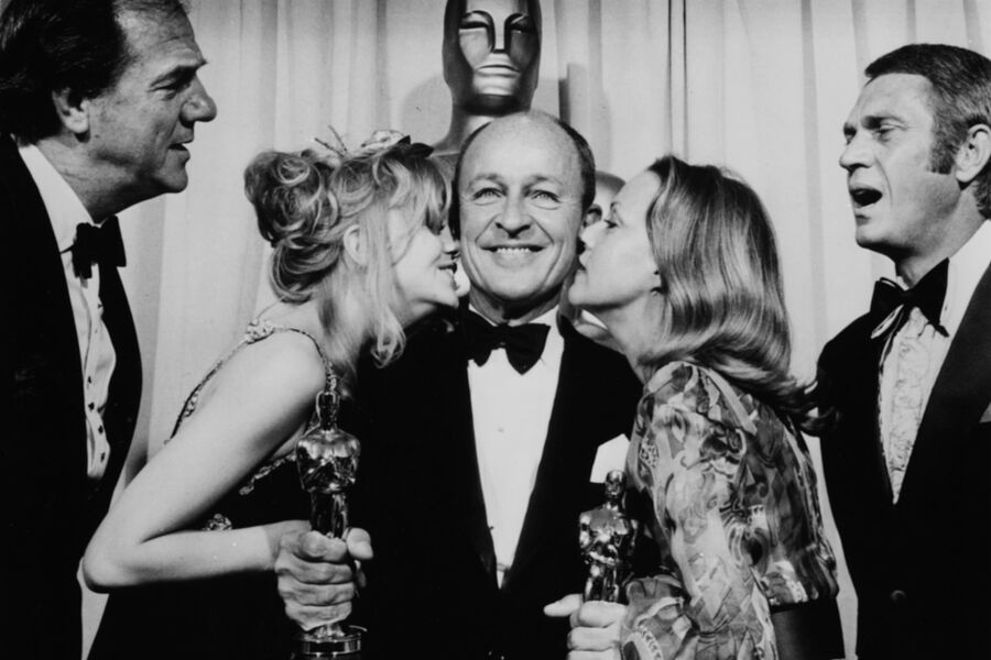 Американская актриса Голди Хоун и французская актриса Жанна Моро целуют в&nbsp;щеки американского кинопродюсера Фрэнка Маккарти во время 42-й церемонии вручения премии «Оскар» в&nbsp;павильоне Дороти Чандлер в&nbsp;Лос-Анджелесе, Калифорния, 7&nbsp;апреля 1970&nbsp;года