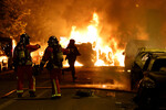 Пожарные тушат горящие автомобили во время столкновений между протестующими и полицией после гибели 17-летнего подростка, убитого французскими полицейскими в Нантере, пригород Парижа, Франция, 28 июня 2023 года
