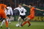 Капитан голландцев Марко ван Боммель пытается отобрать мяч у немца Тони Крооса