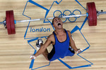 30 июля. Тяжелоатлет Мануэль Мингинфель из Индонезии роняет штангу во время олимпийских соревнований в Лондоне. 