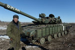 Ополченец Луганской народной республики у трофейного украинского танка Т-64 на окраине Дебальцево