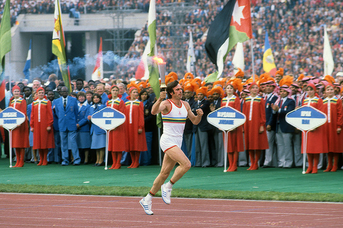 Трехкратный олимпийский чемпион Виктор Санеев вносит факел олимпийского огня на&nbsp;стадион 