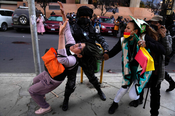 Полицейский разнимает участниц проправительственной и антиправительственной акции протеста в&nbsp;Ла-Пасе, Боливия, 21&nbsp;июля 2022&nbsp;года