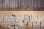 Мигранты, ищущие убежища в США, пересекают забор из колючей проволоки, установленный для предотвращения проникновения мигрантов в Соединенные Штаты, Сьюдад-Хуарес, Мексика, 31 января 2024 года
